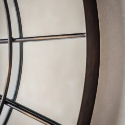 round metal industrial style window mirror finished in a distressed bronze