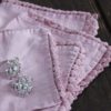 set of four square pink linen napkins with embroidered lace edging