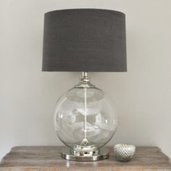 large glass ball shaped table lamp with chrome central pole, base and neck with a dark grey drum linen lampshade