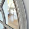 large wooden arched window mirror with a distressed grey painted finish