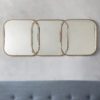 gold rectangular wall mirror consisting of three mirrors overlapping in a linked design