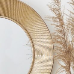 circular wall mirror with a wide ribbed copper frame