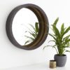 small round wall mirror with a deep bronze metal dimpled frame with contrasting gold interior