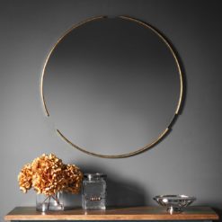 contemporary round gold wall mirror with a polished edge and three tubular sections to the outstide of the frame