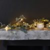 long faux mistletoe Christmas garland decorated with berries, warm-white lights and dusting of sparkles