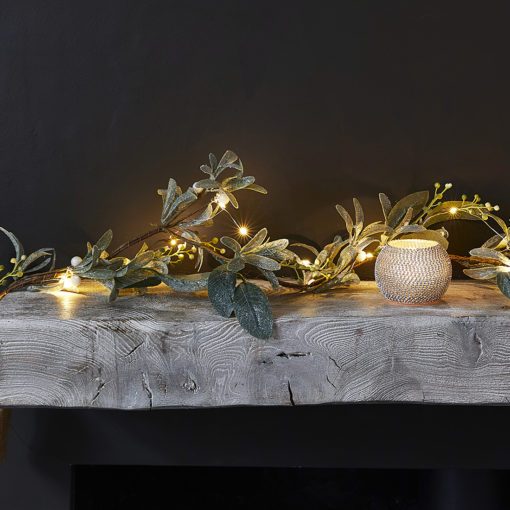 long faux mistletoe Christmas garland decorated with berries, warm-white lights and dusting of sparkles