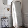 rectangular metal framed leaner mirror with curved corners and finished in a lightly distressed champagne silver leaf