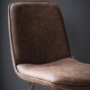 set of two lightly padded dining chairs upholstered in a vintage brown faux leather with metal legs
