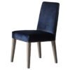 a pair of high-backed dining chairs upholsterd in a deep blue velvet and finished with ash wooden legs