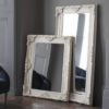 a highly decorative framed wall or floor standing mirror finished in ivory