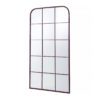 a tall slim rectangular wall mirror with a natural metal frame with curved corners and a window pane design