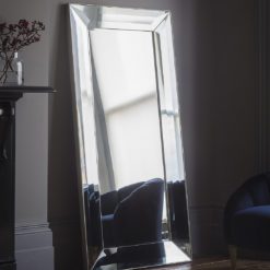 a tall rectangular all glass floor standing mirror with a deep silver edged frame