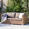 square garden sofa constructed from rattan with brown seat pads and cushions