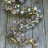 christmas light garland full of frosted pine cones, faux pine, berries, bark stars, silver baubles and warm white LED lights
