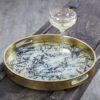 round tray finish in gold leaf with a decorative glass base and decorative blossom design