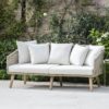 contemporary two-seater outdoor sofa with a polyrope framed seat and tapered acacia wooden legs complete with ivory seat pads and scatter cushions
