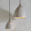 available in a large and small size, domed metal pendant lights finished in a light grey with brass fittings