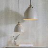 available in a large and small size, domed metal pendant lights finished in a light grey with brass fittings
