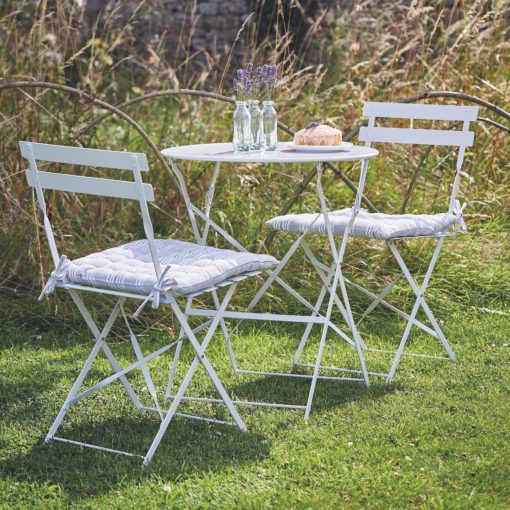 chalky-white painted metal bistro set comprising round table and two folding chairs