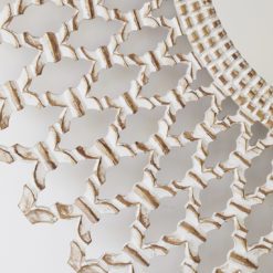 large round wooden wall mirror with carved cut-out design and painted white finish with warm gold detail