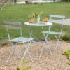 outdoor metal bistro dining set consisting of round table and two chairs with a painted pale blue finish