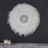 large round wall decoration made of ivory feathers and a decorative shell centre