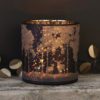 large glass brown/black tealight holder with a shiny copper inner and woodland forest complete with stag silouhette