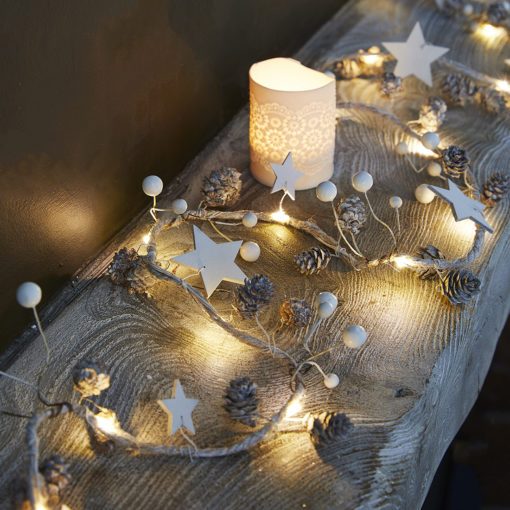 natural woodland ligh garland decorated with white berries and small white pine cones interspersed between warm-white lights