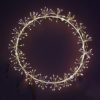 45cm diameter white wired wreath adorned with warm-white starburst clusters - mains operated