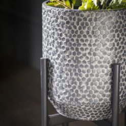 metal planter with a washed grey hammered finish on a metal black stand