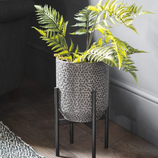 metal planter with a washed grey hammered finish on a metal black stand