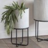 set of two round industrial style white metal planters with a ribbed design set on a black framed stand