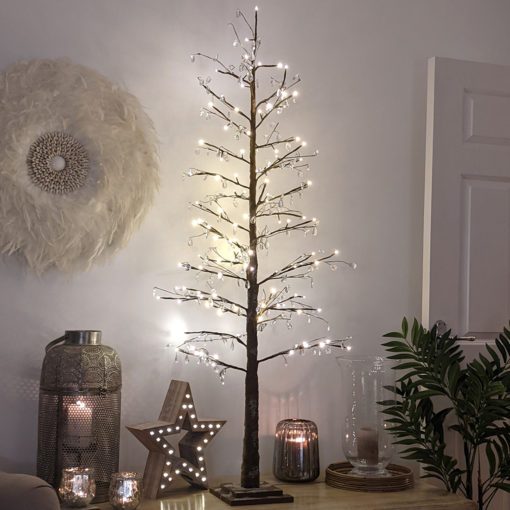 faux indoor christmas tree constructed from wired branches finished in brown with a dusting of snow and adorned with clear crystal droplets and warm white lights