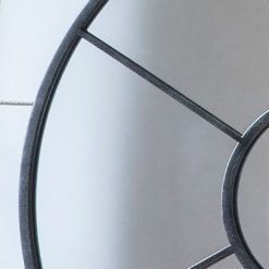 round wall mirror with a black metal window frame