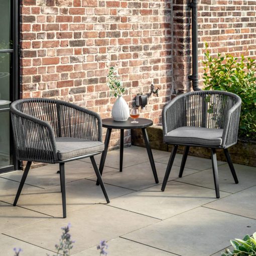 set of two outdoor tub chairs with a waterproof rope weave and powder coated aluminium frame with charcoal cushion and matching side table