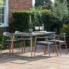 contemporary outdoor dining set featuring a dining table and four dining chairs with wood effect legs and woven rattan seat backs and table top