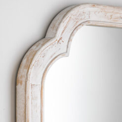 vintage style wooden wall mirror with a curved top and distressed white painted finish