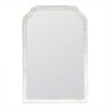large wooden framed wall mirror with a curved top and white-washed painted finish