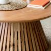contemporary round wooden coffee table with a natural finish and slatted base