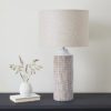 white ceramic tall table column lamp with textured ceramic detailing and natural linen lampshade