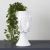 tall contemporary white vase with a pedestal base and multi-face design