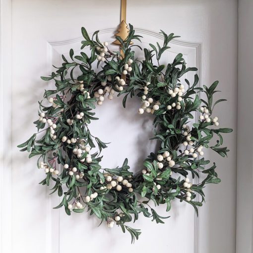 large door twig based wreath adorned with individually wired mistletoe bunches and white berries