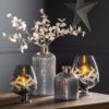 smokey grey glass footed hurricane lanterns and textured bottle vases