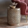 drum shaped round metal side table with a fretwork surround and hammered top finished in a lightly distressed pale gold