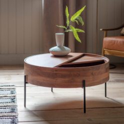 round wooden coffee table with iron rod legs and a revolving top concealing storage space within the table