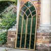 gothic inspired arched outdoor garden mirror with gold frame