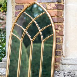 gothic inspired arched outdoor garden mirror with gold frame