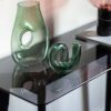 contemporary console table with slim black wooden legs and smoked glass top