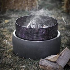 contemporary round outdoor fire pit with a punched metal bowl placed on a grey fibre clay round base