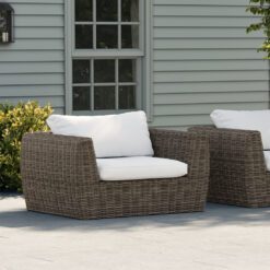 large rattan armchair with off-white cushions